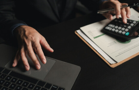accountant in front of a laptop using a calculator