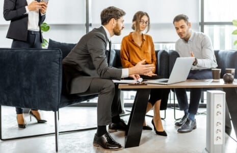Young couple solving some financial issues with financial consultants at the luxury bank office. Investment or lending concept for a young family