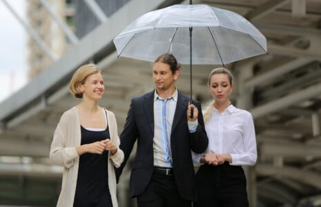 accountants standing under an umbrella discussing PII
